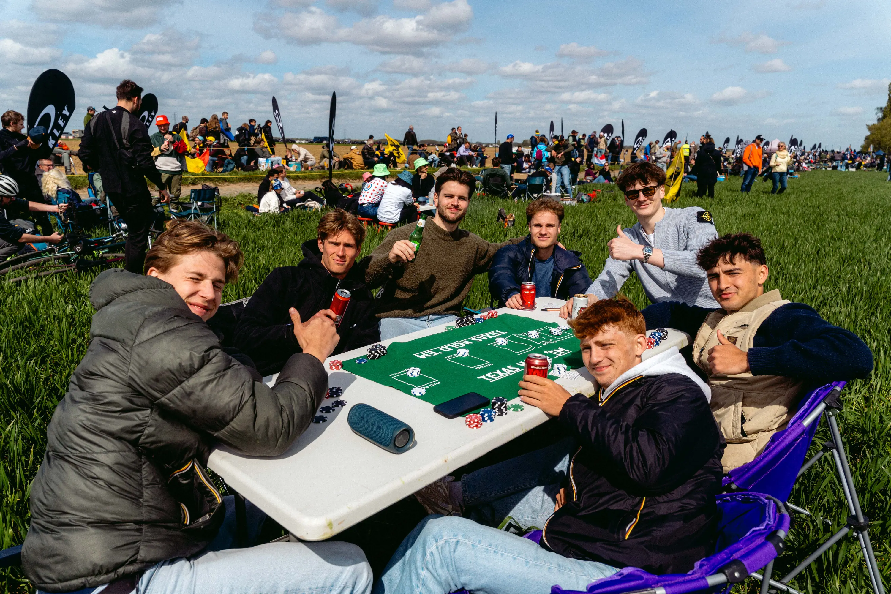 Spectators playing poker at the roadside while waiting for the race