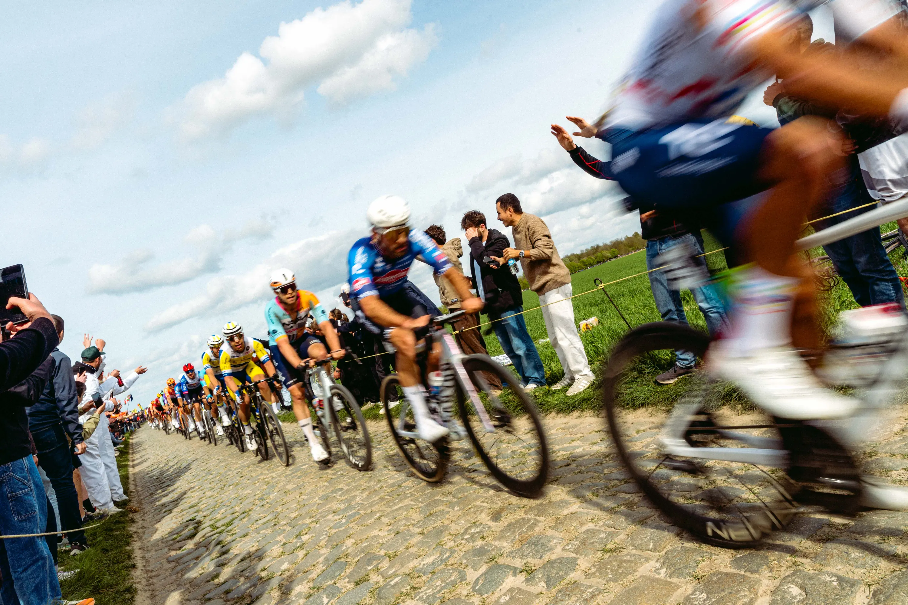 Wide-angle view of the pavé with riders on the Carrefour de l'Arbre