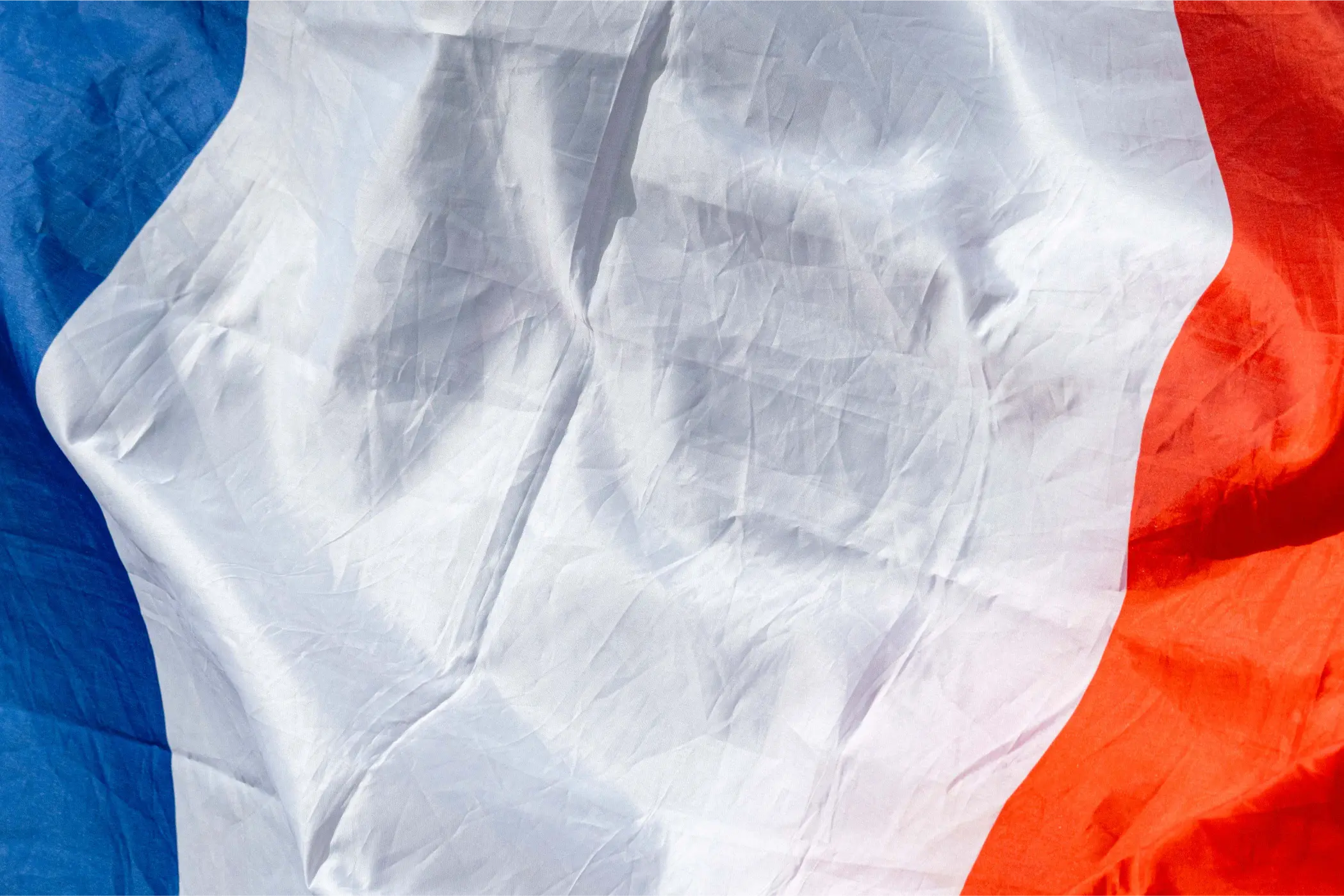Close-up of a French flag rippling in the wind at the roadside