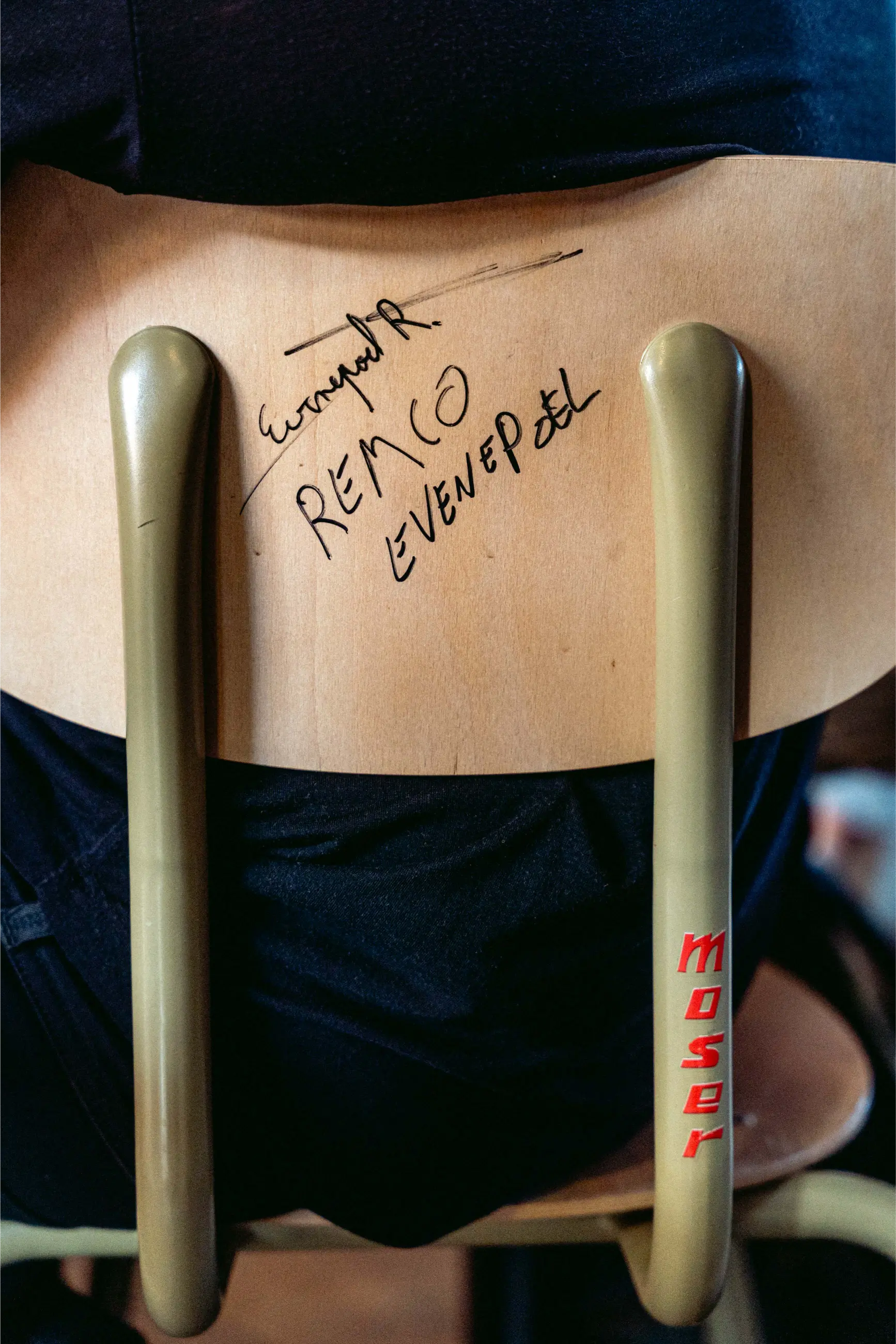 Rückenlehne eines Holzstuhls mit Autogramm von Remco Evenepoel in schwarzem Marker